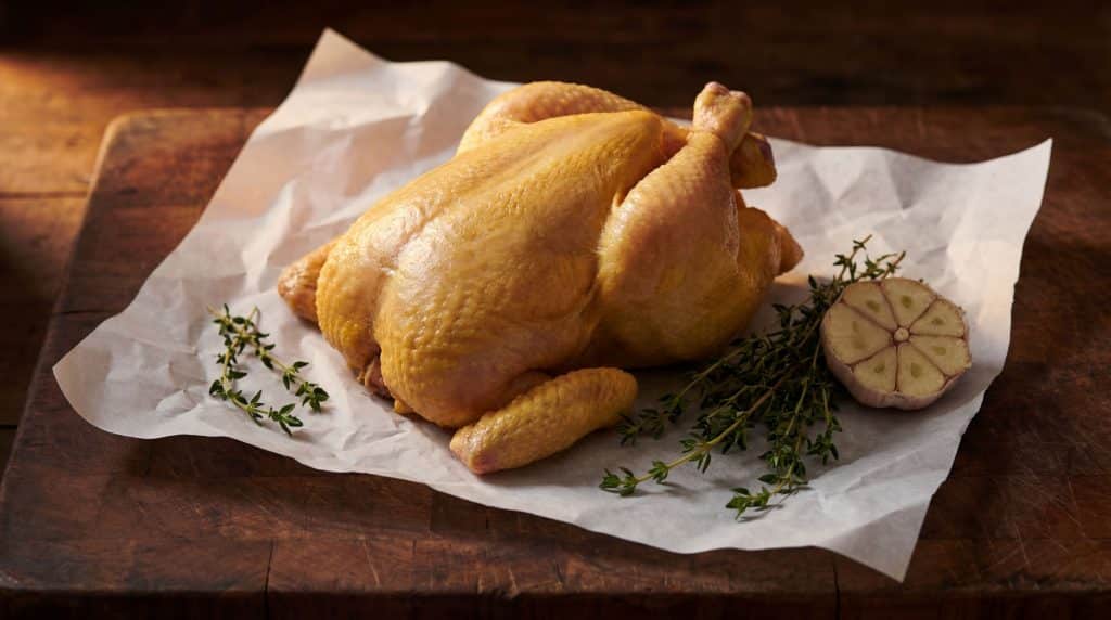 What Is Spatchcock? Australia's Answer to Cornish Game Hen 1 A whole raw spatchcock chicken on butcher paper, showing the small size and plump breast of this young Australian poultry bird