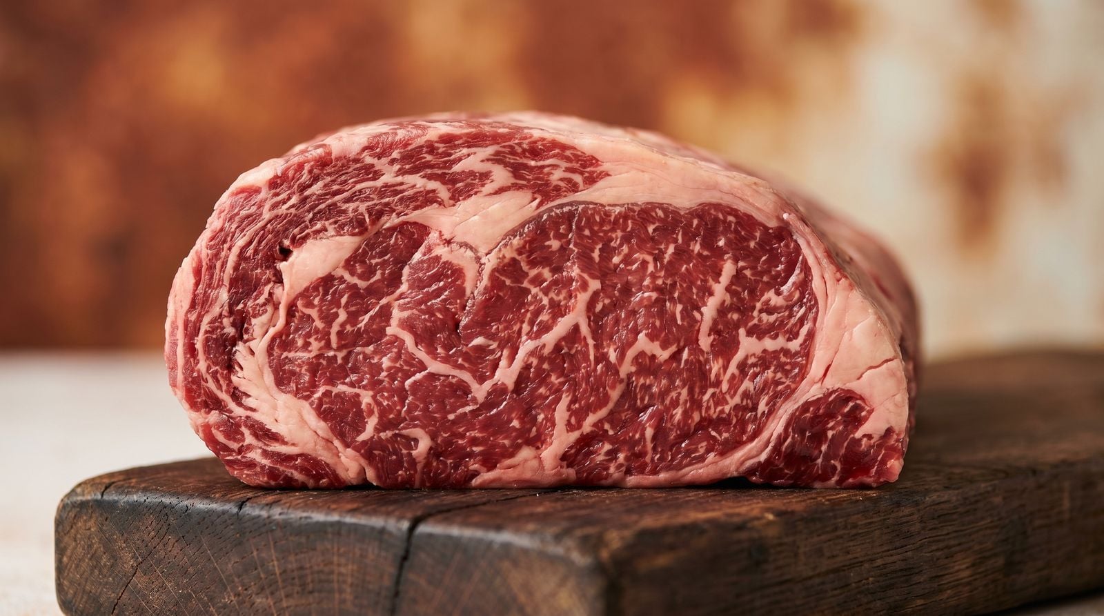 Angus Beef Guide: What Makes It Australia's Top Breed 2 Close-up of raw Angus beef scotch fillet showing fine intramuscular marbling on dark timber