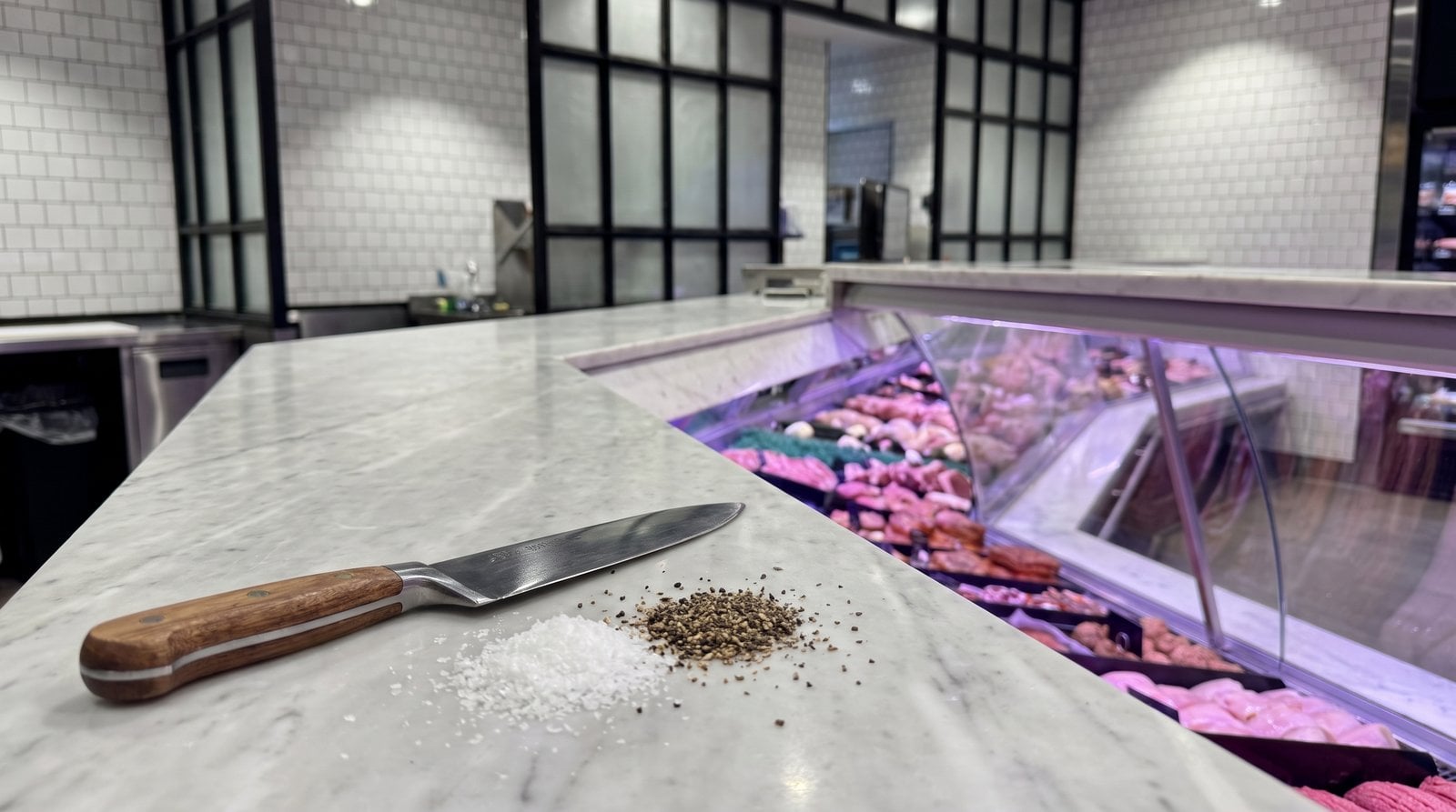Your Local Butcher at Westfield Miranda: What to Look For 4 A butcher's knife resting on the marble counter at Pryde Butchery, fresh cuts visible in the display case behind